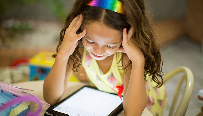 Young girl using an iPad - good broadband plans for families