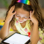 Young girl using an iPad - good broadband plans for families