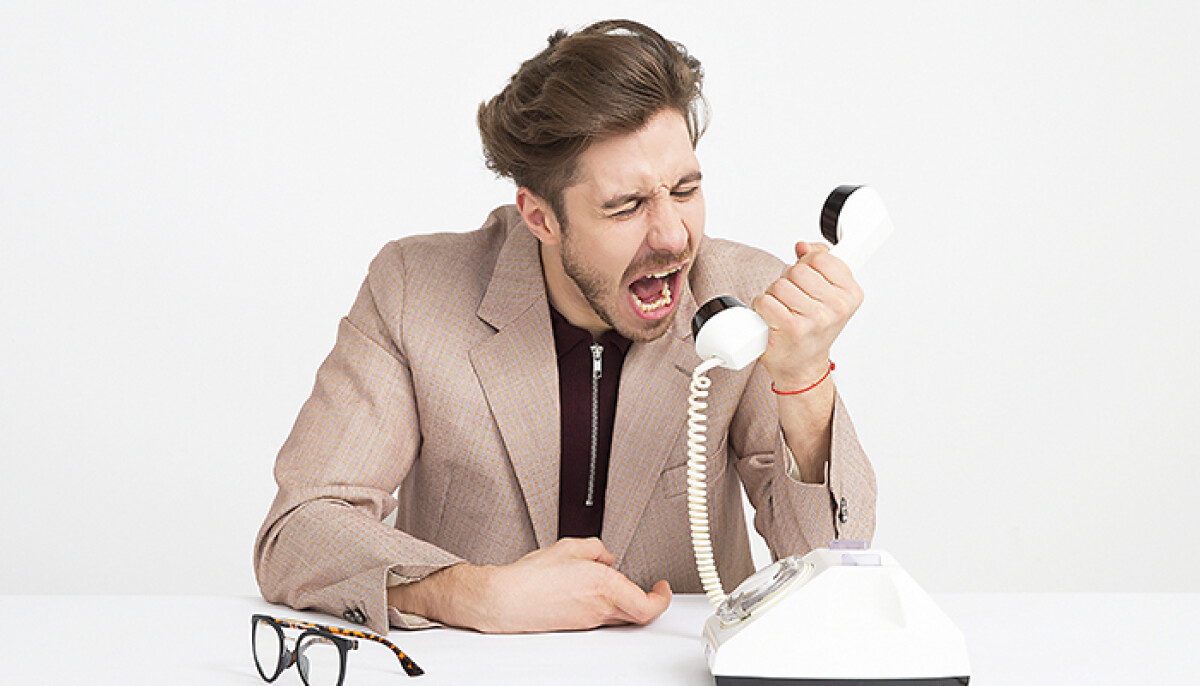 Frustrated man yelling into phone - Broadband provider top complaints